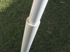 a white baseball bat sitting on top of a lush green field