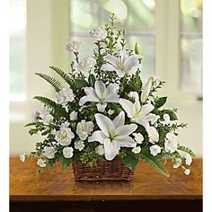 a basket filled with white flowers on top of a wooden table