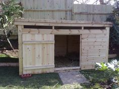 a wooden shed with doors open in the yard