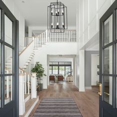 a large hallway with stairs leading up to the second floor and an open door that leads to another room