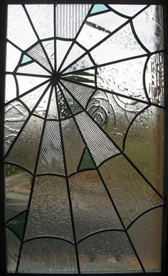 a close up of a stained glass window with drops of water on the windowsill