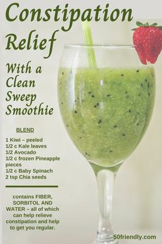 a green smoothie in a glass with a straw and a strawberry on the top