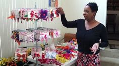 a woman standing in front of a table filled with lots of ribbons and gift bags