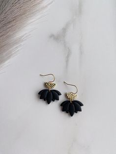 Handmade polymer clay earrings made with polymer clay which is very lightweight. These black and gold dangle earrings are made with hypoallergenic hardware that is lead and nickel free. These black and gold flower earrings are your perfect minimal neutral earring. Enjoy your new handmade dangle earrings! Message us with any questions, thank you! Minimalist Handmade Black Earrings, Black Polymer Clay Earrings For Everyday, Black Polymer Clay Jewelry With Matching Earrings, Everyday Black Polymer Clay Earrings, Elegant Black Polymer Clay Jewelry, Handmade Black Polymer Clay Earrings, Black Polymer Clay Jewelry With Ear Wire, Black Polymer Clay Earrings With Ear Wire, Black Dangle Flower Earrings With Ear Wire