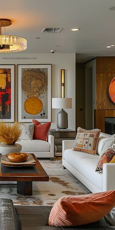 a living room filled with white furniture and lots of orange pillows on top of it