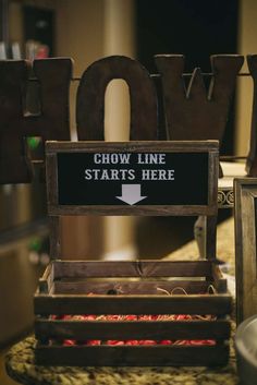 a sign that says chow line starts here on the back of a wooden crate with flowers in it