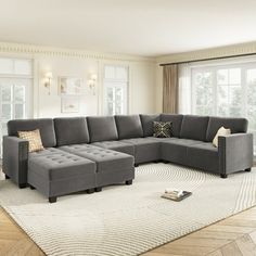 a living room with a gray sectional couch and white rugs on the hardwood floor