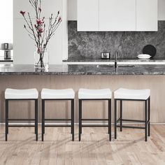 four stools in front of a kitchen island