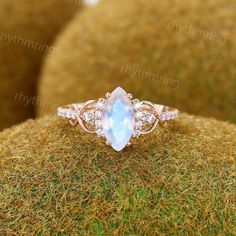 an oval cut blue topazte and diamond ring on mossy surface with white background