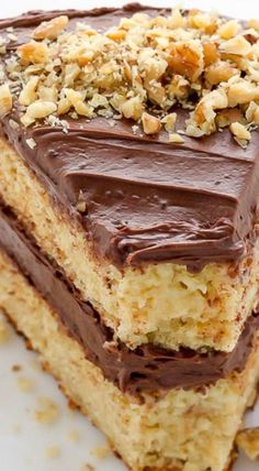 a piece of cake with chocolate frosting and nuts on top