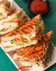 three grilled sandwiches on a white plate