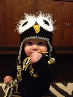 a baby wearing a knitted hat and eating something