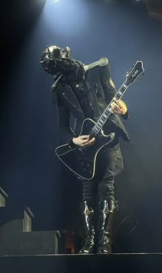 a person with a guitar in their hand on stage at a music festival or concert