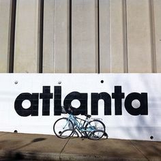 a bicycle parked in front of a sign that says atlanta on the side of a building