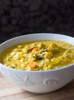 a white bowl filled with soup on top of a wooden table