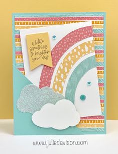 a card with a rainbow and clouds on it