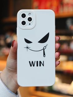 a person holding up a phone case with an angry face on it that says win