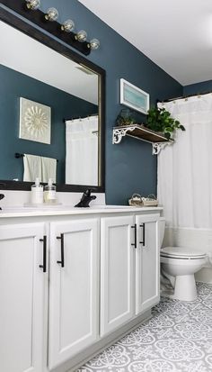 a bathroom with blue walls and white cabinets