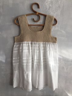 a white dress hanging on a wooden hanger