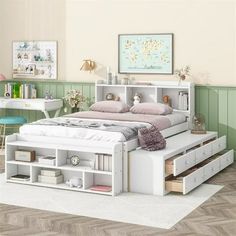 a white bed with drawers underneath it in a room