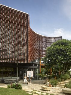 people are walking around in front of a building made out of wine bottles and bricks