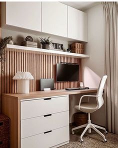 a desk with a computer on top of it next to a white chair and window