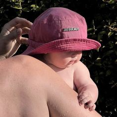 a man holding a baby wearing a pink hat