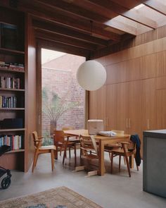 a dining room table and chairs in front of a bookshelf