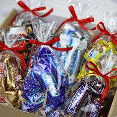 a box filled with assorted candy wrapped in red ribbon