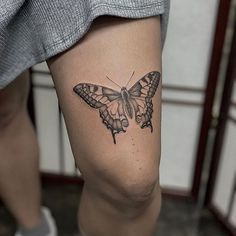 a woman's leg with a butterfly tattoo on her left thigh and right leg