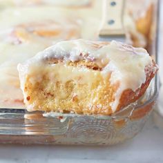 a close up of a piece of cake in a glass dish with icing on top