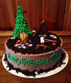 a birthday cake is decorated with an image of a tree and camping camper's tent