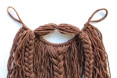 a close up of a piece of cloth with long braids on the sides and one knoted at the top