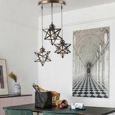 a dining room table and chairs with art on the wall behind them in an apartment