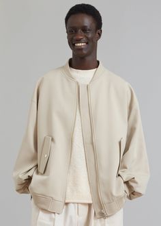 Color: Natural Lightweight woven fabric Classic oversized bomber Baseball collar Slight drop shoulders Flap pockets with snap closure Rib knit trim Front zip closure Lined 78% Polyester 17% Rayon 5% Spandex Lining: 100% Polyester Dry Clean By The Frankie Shop. Imported Oversized Neutral Button-up Outerwear, Urban Khaki Cotton Windbreaker, Oversized Utility Button-up Outerwear, Oversized Double-breasted Beige Outerwear, Men's Bomber Jacket, Denim Suit, Paris Woman, Leather Texture, Swimwear Accessories