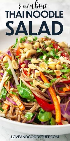 a white bowl filled with noodles and veggies on top of a marble table