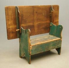 an old wooden bench sitting on top of a white floor next to a gray wall