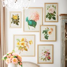 a table with flowers and pictures on the wall