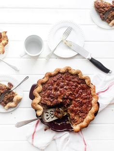 a pecan pie on a table with plates and utensils