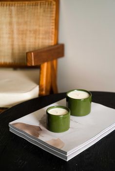 two green candles sitting on top of a book