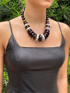 This stunning statement necklace is bound to get noticed. The classic black and white, softened by the gold spacers and the brown tiger's eye bead will make a great choice for any one color top (whether low-cut neck or turtleneck) and will spice up your outfit. The necklace is massive, yet not too heavy. It is an elegant piece that will make you look cool and fearless in the same time. Great choice for a birthday gift for wife, mother, daughter, or girlfriend. FAST FREE SHIPPING The necklace does not stretch, but the length can be adjusted using an extension cord. For the necklace to last a long time, do not deform it and use it only for its intended purpose! Avoid contact with moisture and perfume. When storing, avoid direct sunlight. DELIVERY: The necklace will be gift wrapped. Delivery Bold Black Jewelry For Gifts, Bold Black Jewelry For Gift, Bold Black Jewelry Gift, Black Jewelry With Large Beads, Elegant Chunky Necklaces For Parties, Elegant Chunky Necklace For Parties, Gift Black Choker With Large Beads, Black Choker With Large Beads, Bold Black Necklace For Gifts