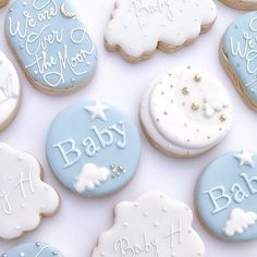 baby cookies decorated with blue and white icing are arranged in a pattern on a table