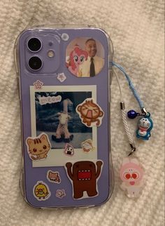 an iphone case with stickers on it next to a lanyard keychain