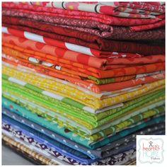 a stack of colorful fabrics sitting on top of each other in different colors and patterns