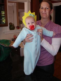 a woman holding a baby wearing a clown nose