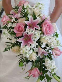 a bride holding a bouquet of pink and white flowers