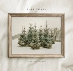 a snowy scene with trees in the foreground and text that reads, art prints