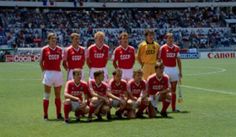 a group of men standing on top of a soccer field in front of a crowd