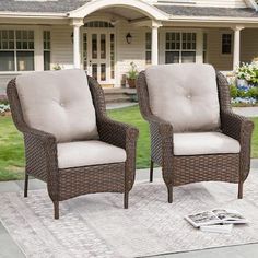 two chairs sitting on top of a rug in front of a house