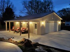 a garage with two couches in front of it and lights shining on the side